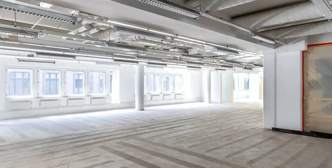 Valoisa ja avoin raakapinnoilla oleva kolmannen kerroksen toimistotila Kluuvi Officesissa